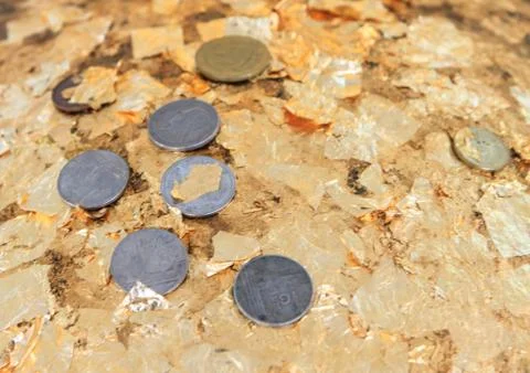 Coins on gold leaf 库存照片
