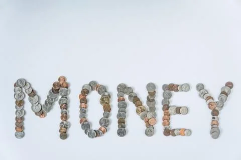 Coins isolated on solid white background spelling the word Money Stock Photos