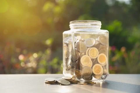 Coins in jar with money stack, Concept finance, accounting, business and savi Stock Photos