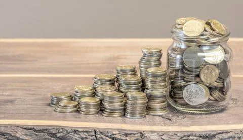 Coins in a jar on the table Stock Photos