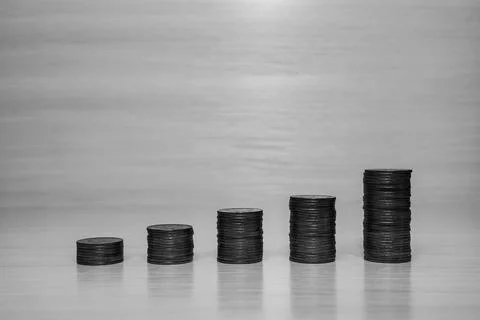 Coins on light background folded in the form of a growing graph Stock Photos