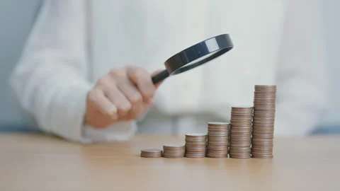 Coins money stack growing with magnifier glass. Money saving, Inflation, ta.. Stock Footage 284702846