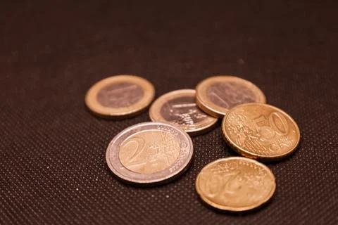 Coins scattered on a dark surface, capturing the essence of everyday transa.. Stock Photos