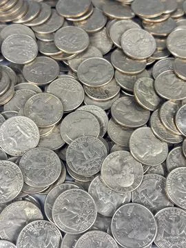Coins scattered on a flat surface in bright light during the day Stock Photos