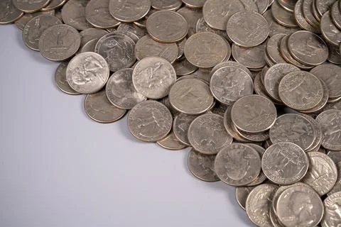 Coins scattered on a flat surface showing different designs and years Stock Photos