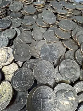Coins spread out on a flat surface in a large pile during daytime Stock Photos
