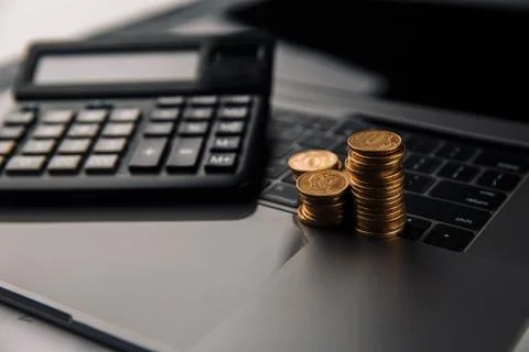 Coins stack with calculator on laptop. Grwoth business success concept Stock Photos