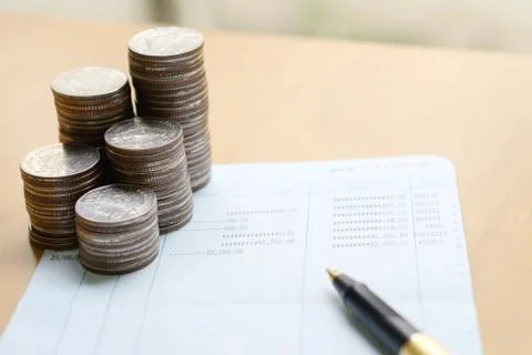 Coins stack in columns with saving book finance and banking concept for backg Stock Photos
