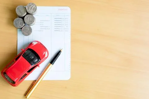 Coins stack in columns, saving book, car. Finance and banking concept. Stock Photos