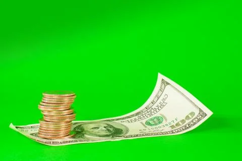 Coins stacked in bars laying on stack of 100 dollar bill Stock Photos
