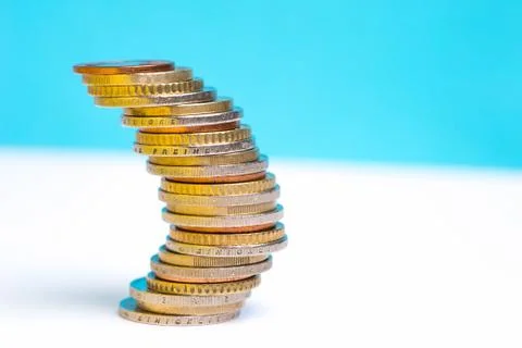 Coins stacked on each other in different positions on a blue and white backgr Stock Photos