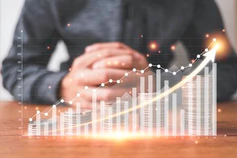 Coins stacking with virtual graph and increase arrow in front of businessman. Stock Photos