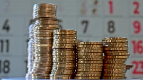 Coins Stacks in Front of Calendar Representing Savings, Investment Stock Footage 322098141