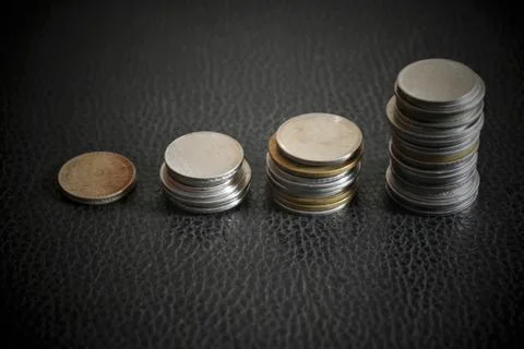 Coins stacks with a growth multicolor graph on silver sparkling bokeh backgro Stock Photos