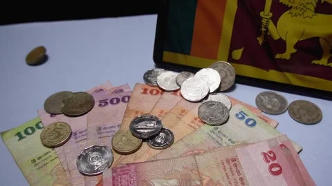 Coins Tossed from Both Sides onto Table with Sri Lankan Notes and Flag Stock Footage 300096305