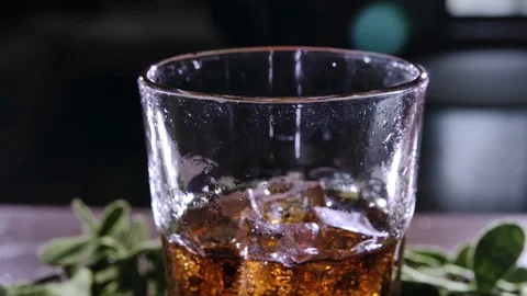 Cola with bubbles in glass. A brown drink is poured into a glass with ice. 스톡 동영상 120554580