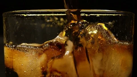 Cola is filled in a glass with ice in front of black background Stock Footage 85435015