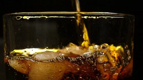 Cola is filled in a glass with ice in front of black background Stock Footage 85435315