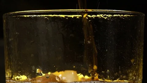 Cola is filled in a glass with ice in front of black background Stock Footage 85435471