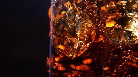 Cola with ice and bubble. Close-up glass of cold cola with ice rotation Video stock 126257103