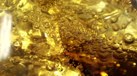 Cola with ice and bubbles in the glass. Close up soda soft drink. Slow motion. Stock Footage
