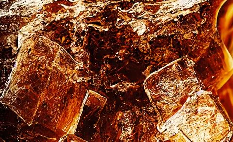 Cola with Ice. Close up of the ice cubes in cola water. Texture of carbonat.. Stock Photos