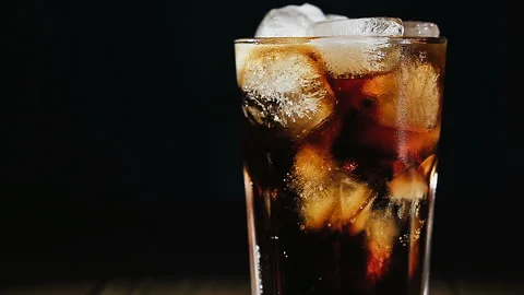 Cola with ice cubes and bubbles in glass, close-up, light moving. Cola drink, Video stock 93446912