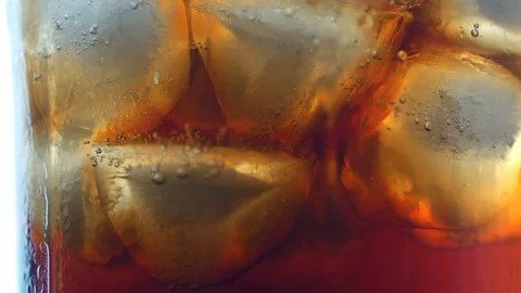Cola with ice cubes background. Cola with Ice and bubbles in glass. Soda closeup Stock Footage 81187476