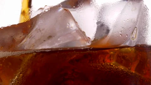 Cola with ice cubes close-up. Cola with Ice and bubbles in glass. Stockbeeldmateriaal 231034975