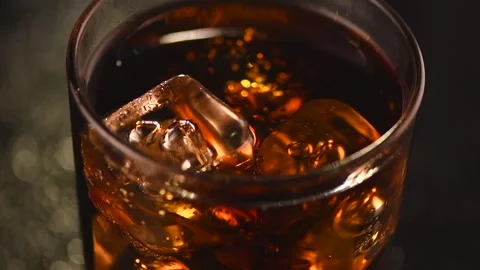 Cola with ice cubes close-up. Cola with Ice and bubbles in glass. Soda closeup.  Stock Footage 280486117
