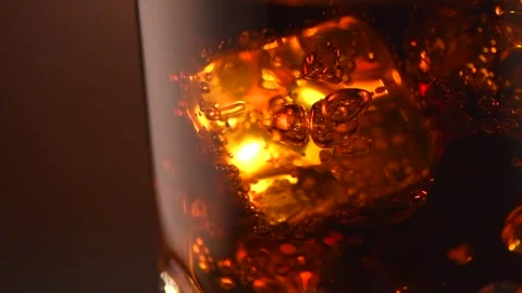 Cola with ice cubes close-up. Cola drink with Ice and bubbles in glass. Soda Stock-Footage 322164305