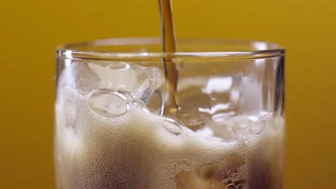 Cola with ice cubes. Cola with Ice and bubbles in glass on orange background. Stock Footage 144172986