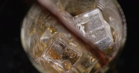 Cola with ice cubes  is poured on black background 스톡 동영상 133628312