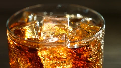 Cola with ice cubes on wooden table. Cola with Ice and bubbles in glass Stock Footage 105037743