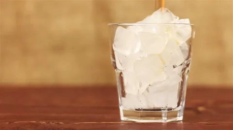 Cola with ice. Pouring Cola with Ice and bubbles in glass on a wooden table and Stock Footage 68838696