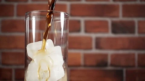 Cola with ice. Pouring Cola with Ice and bubbles in a glass. Slow motion 240 fps Stock Footage 72270919