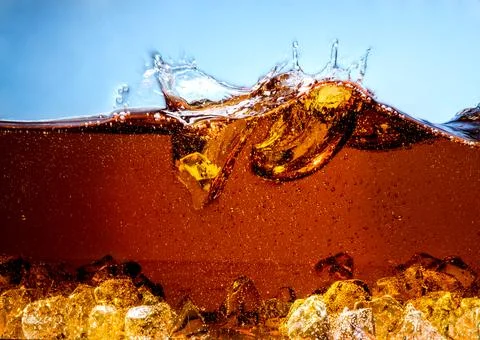 Cola with Ice. Splash with bubbles Stock Photos