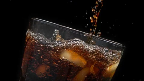 Cola Pouring Into Glass with Ice, Close Up on Black Background Stock Footage 346088264