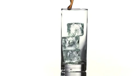 Cola pouring into glass with ice cubes in slow-motion Stock Footage