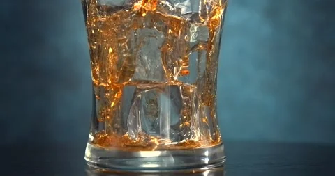 Cola pouring into glass with ice cubes in slow motion Stock Footage 346227364