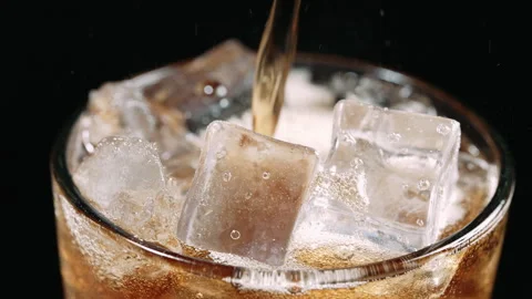 Cola Pouring Over Ice Cubes in Glass, Close Up Stock Footage 346086281
