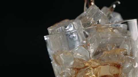 Cola Pouring Over Ice Cubes in Glass, Close Up Stock Footage 346087368