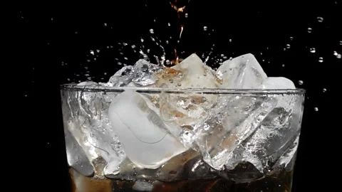 Cola Pouring Over Ice Cubes in Glass, Slow Motion Stock Footage 346088272