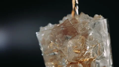 Cola Pouring Over Ice Cubes in Glass, Close Up Stock Footage 346088710