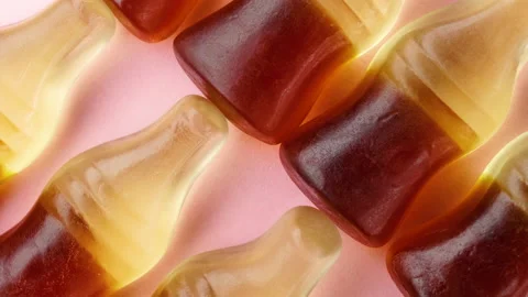 Cola shape jelly beans candies rotating. Pink background, macro Stock Footage 155269539