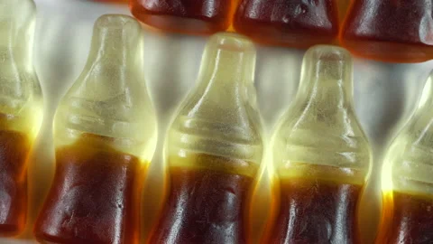 Cola shape jelly beans candies rotating. Pink background, macro Stock Footage 155279933