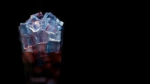 Cola Soda Pouring Over Ice Cubes in Glass on Black Background Stock Footage 346087996