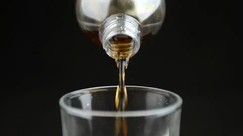 Cola soft drink slow motion poured in to a cold glass front close up view Stockbeeldmateriaal 130427669