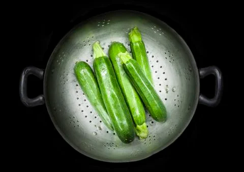 Colander with five courgettes Stock Photos