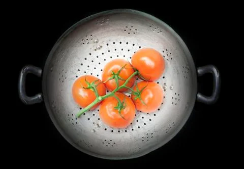 Colander with five tomatoes Stock Photos